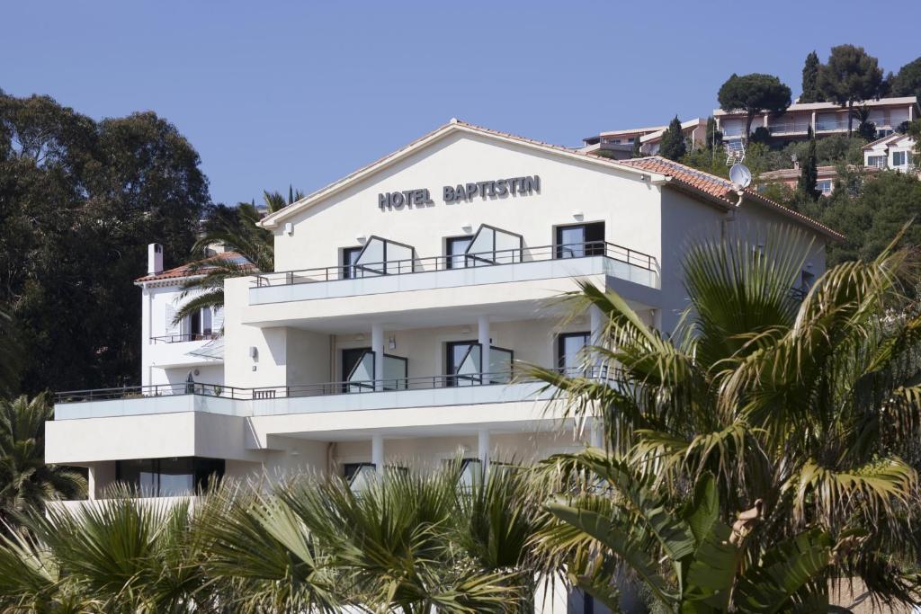 a large white house with a large window at Hôtel Baptistin in Le Lavandou