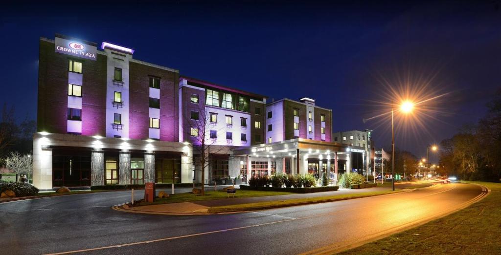 a building with purple lights on a street at night at Crowne Plaza Dublin Airport, an IHG Hotel in Santry