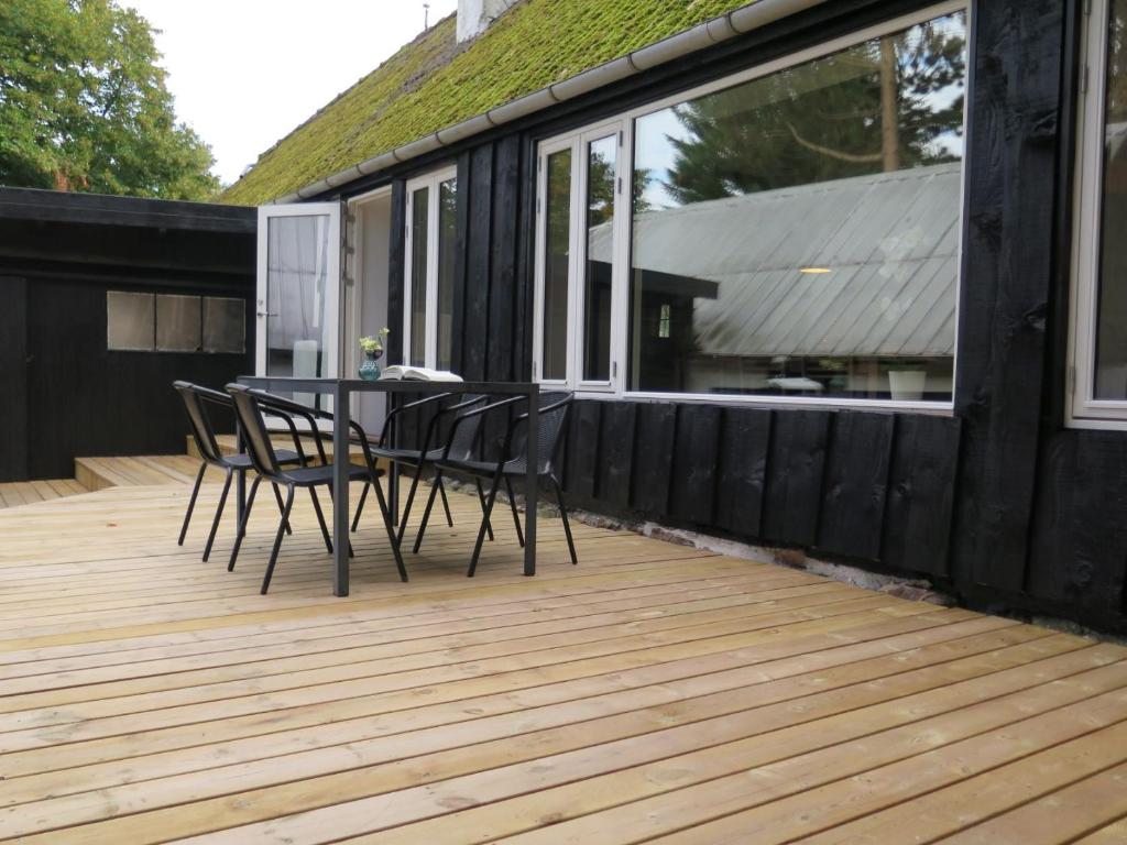 a wooden deck with a table and chairs on it at Ferieidyl in Kettinge