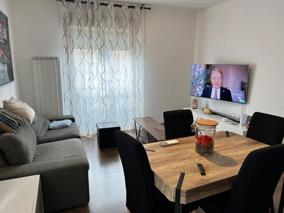 sala de estar con mesa y TV en Grande appartamento in Centro, 4 posti letto, en Gorizia