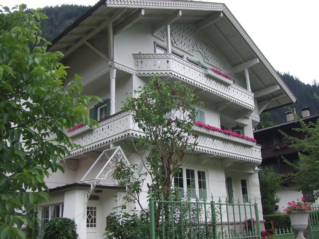 a white house with a balcony and flowers on it at Villa Rauter Mayrhofen in Mayrhofen