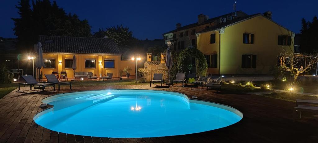 ein Schwimmbad im Garten eines Hauses nachts in der Unterkunft Villa Morro Suites in Morrovalle
