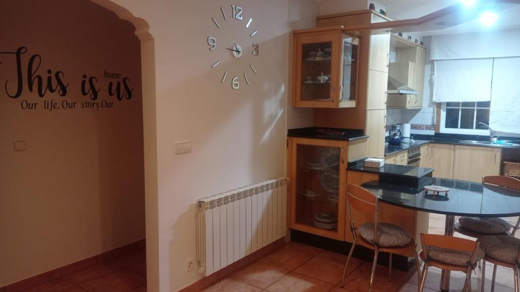 cocina con mesa y pared con reloj en A Morada de Julia, Acogedor apartamento en el balcón del Valle Miñor, en Pontevedra