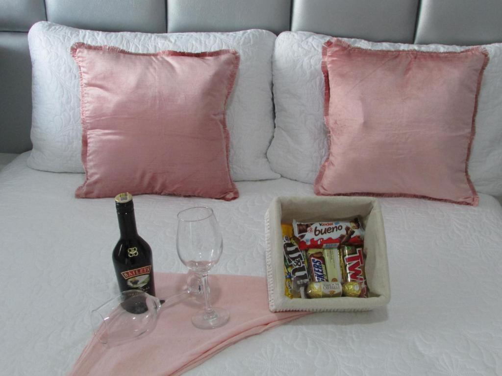 a bed with a bottle of beer and a wine glass at ALESOMAYA APARTHOTEL in Cali