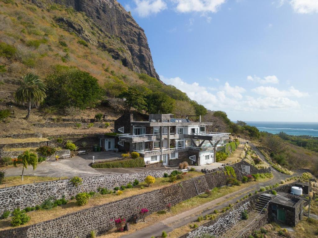 a house on a hill next to the ocean at Villa Cambier by muse villas in Le Morne