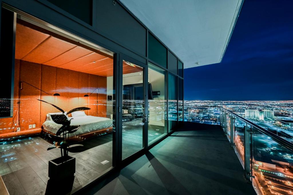 a bedroom with a view of a city at night at StripViewSuites Ultimate Luxury Penthouses Full Strip View & Balcony in Las Vegas
