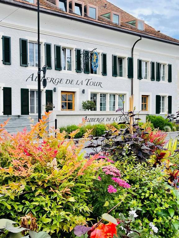 a building with a bunch of flowers in front of it at Auberge de la Tour in Trélex