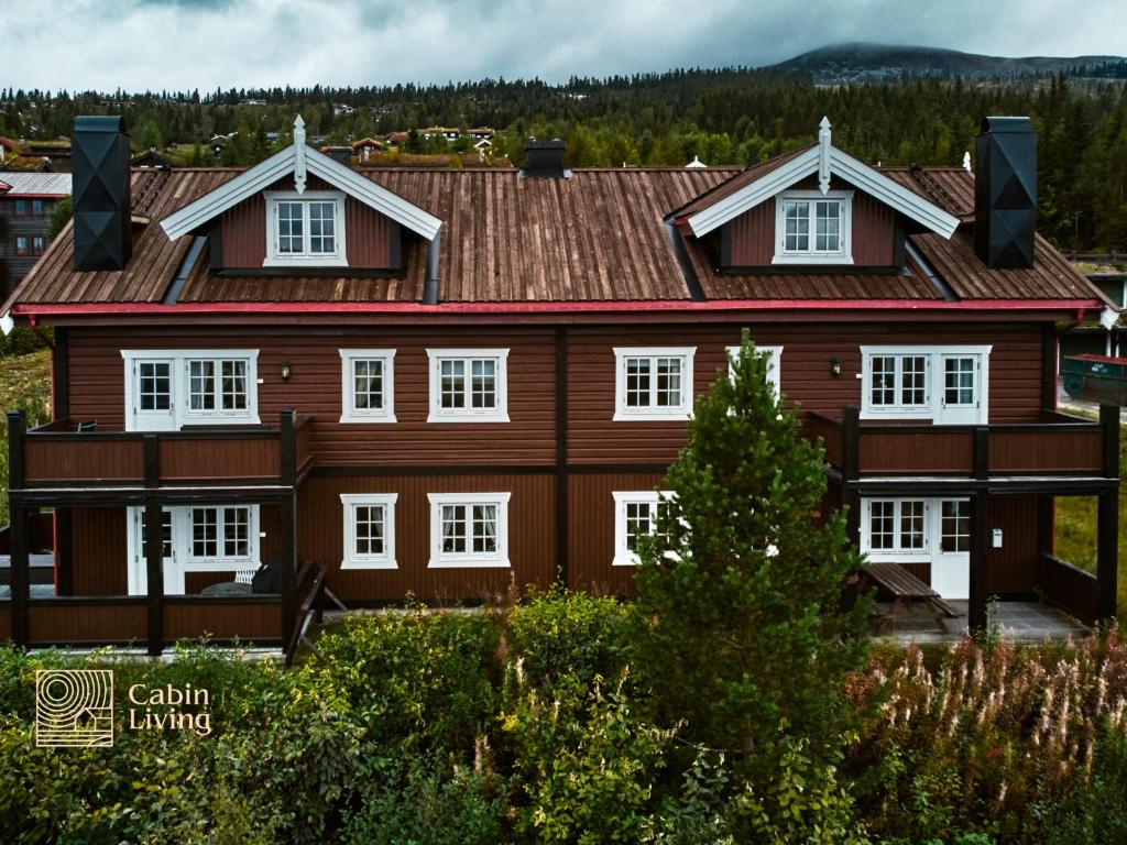 a large wooden house with white windows at Flat in Trysil Ski in ski out and sauna in Trysil