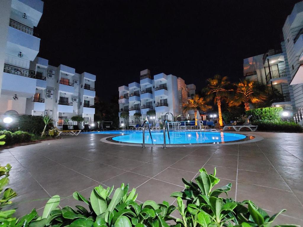 a swimming pool in front of a building at night at Summer rose hotel in Side