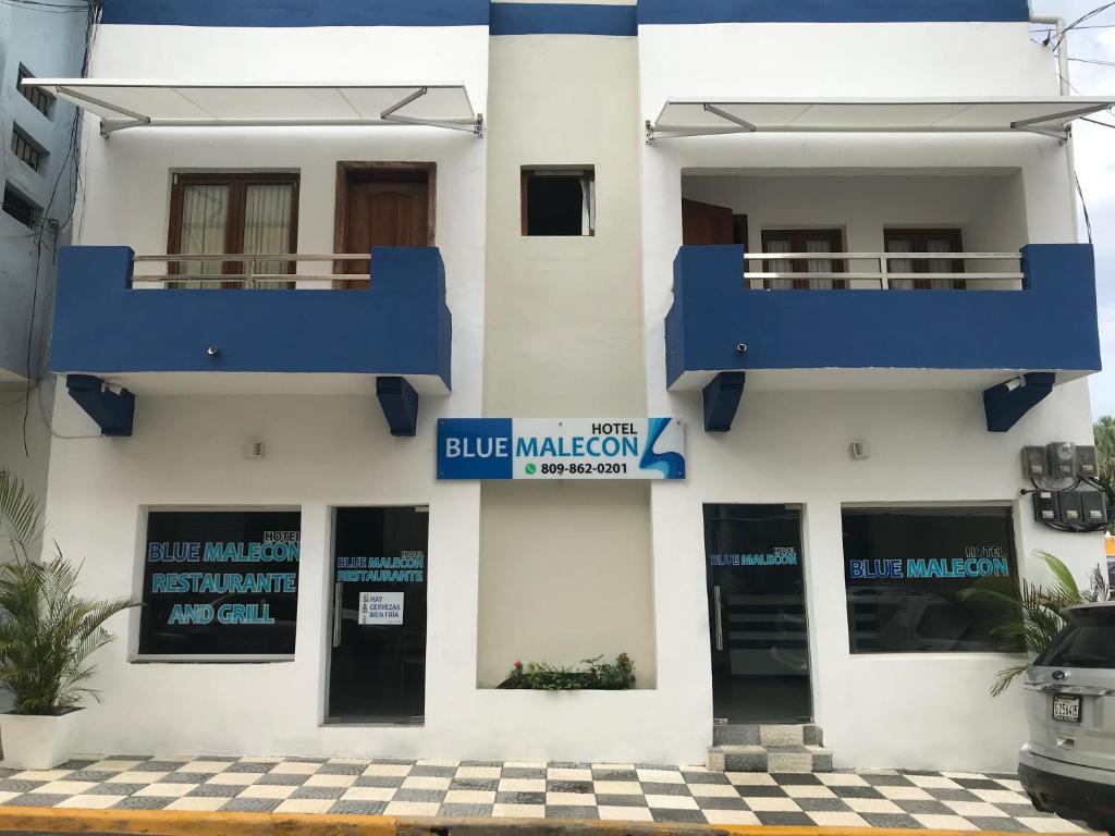 un edificio bianco con un segno di malociazione blu sopra. di Hotel Blue Malecón And Spa a Santo Domingo