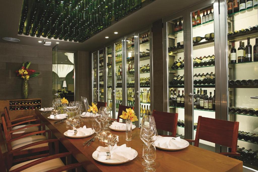 a long table in a restaurant with wine bottles at Secrets Playa Mujeres Golf & Spa Resort - All Inclusive Adults Only in Cancún