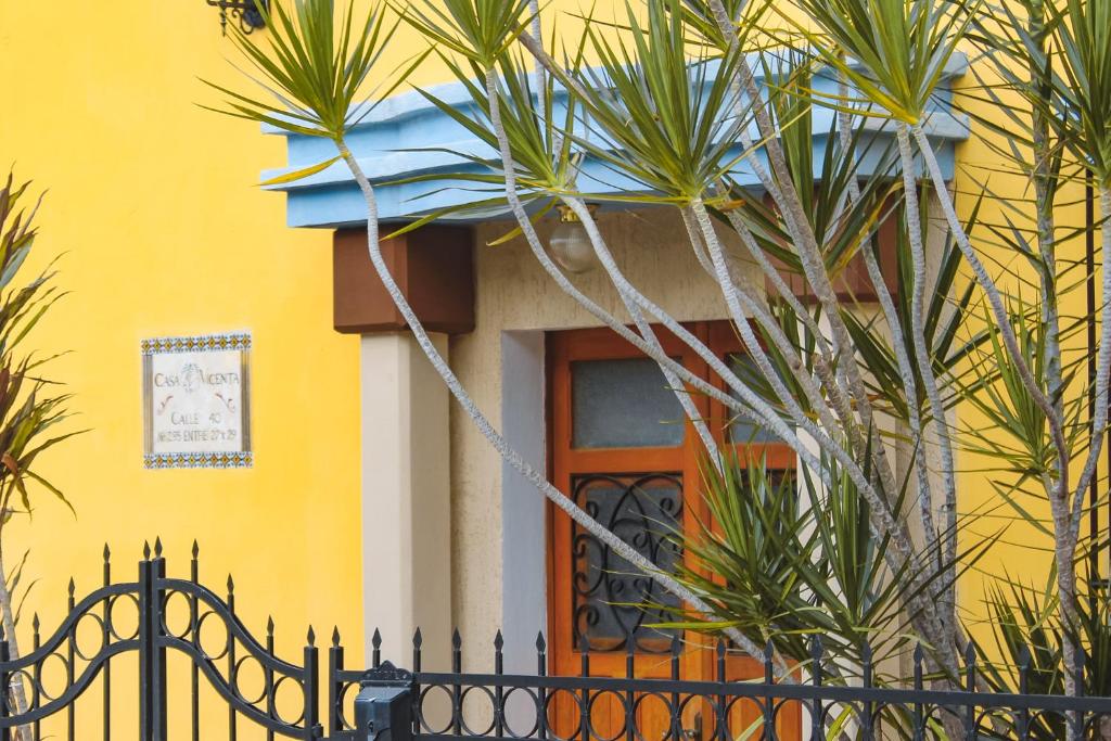 a yellow house with a black fence in front of a door at Casa Vicenta Izamal in Izamal