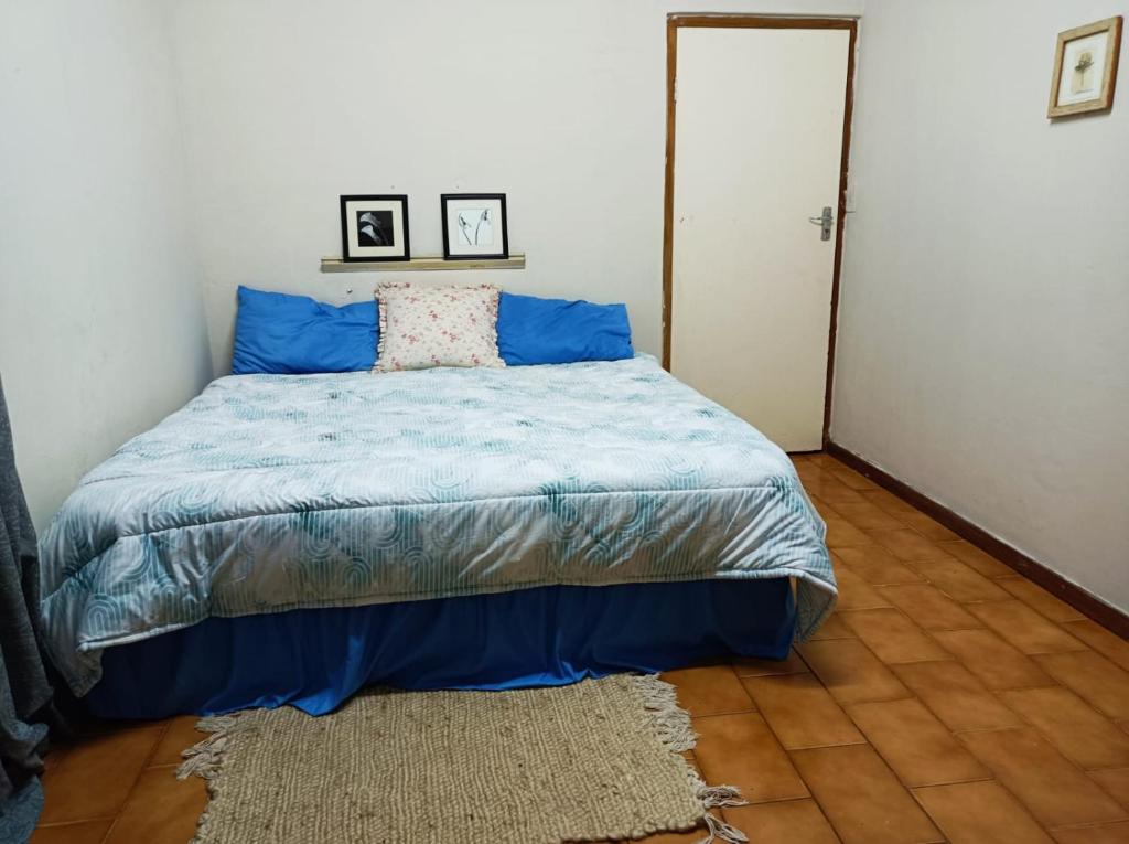 1 dormitorio con cama con sábanas azules y alfombra en 18 on Shores, en Pietermaritzburg