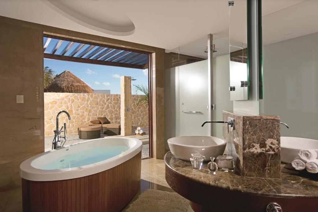a bathroom with a large tub and a sink at Secrets Playa Mujeres Golf & Spa Resort - All Inclusive Adults Only in Cancún