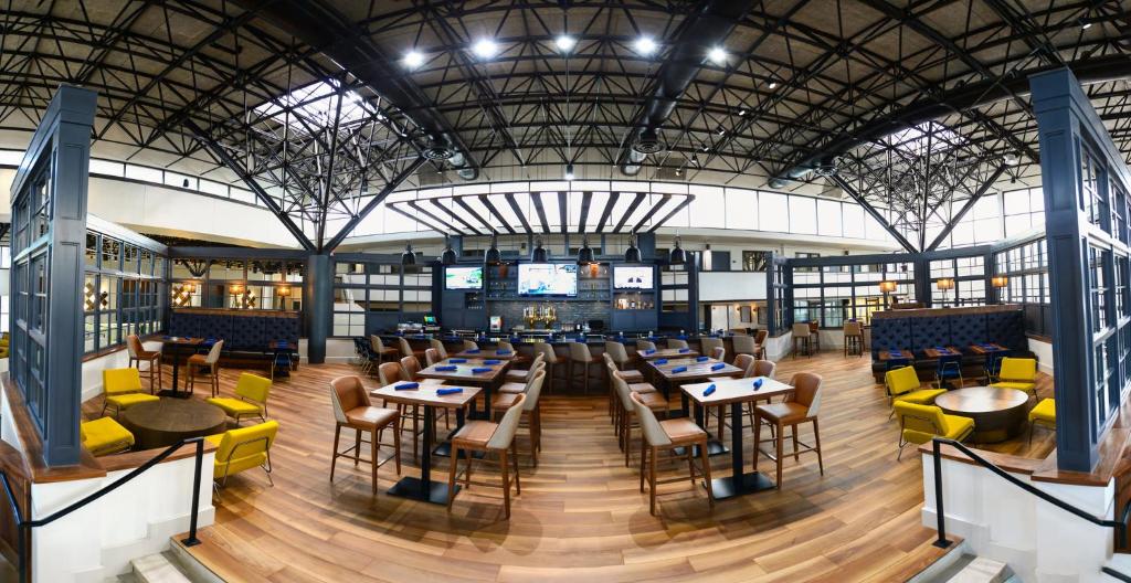 a restaurant with tables and chairs in a building at Crowne Plaza Jacksonville Airport, an IHG Hotel in Jacksonville