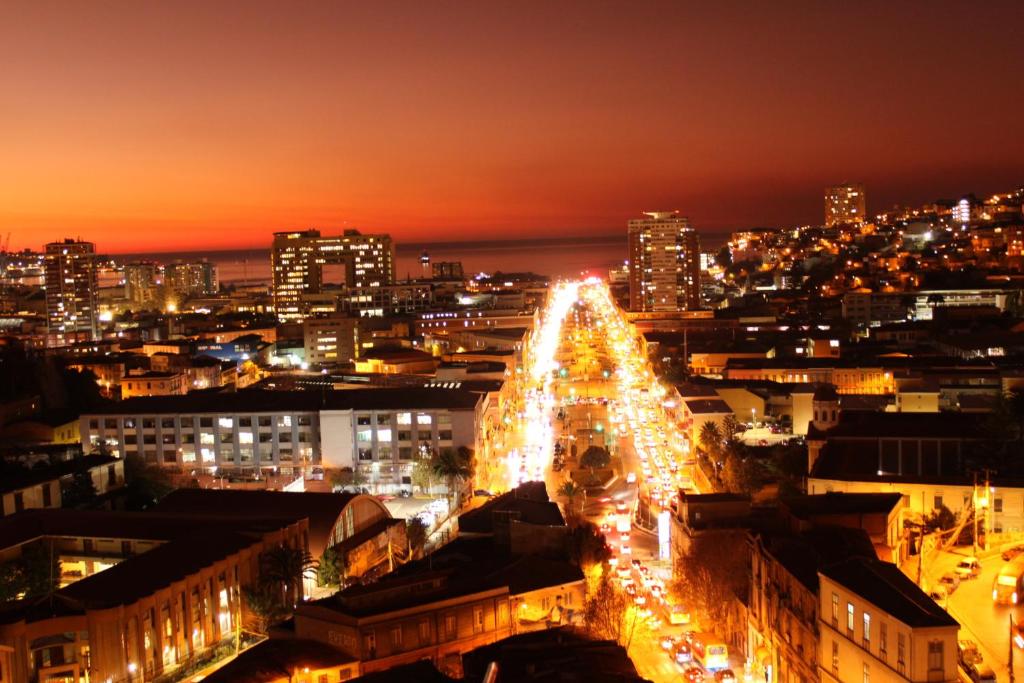 Un árbol de Navidad iluminado en una ciudad por la noche en Hostal brons, en Valparaíso