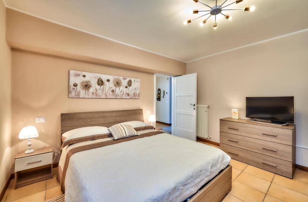Schlafzimmer mit einem Bett und einem Flachbild-TV in der Unterkunft DIMORA SAN LORENZO in Maggio