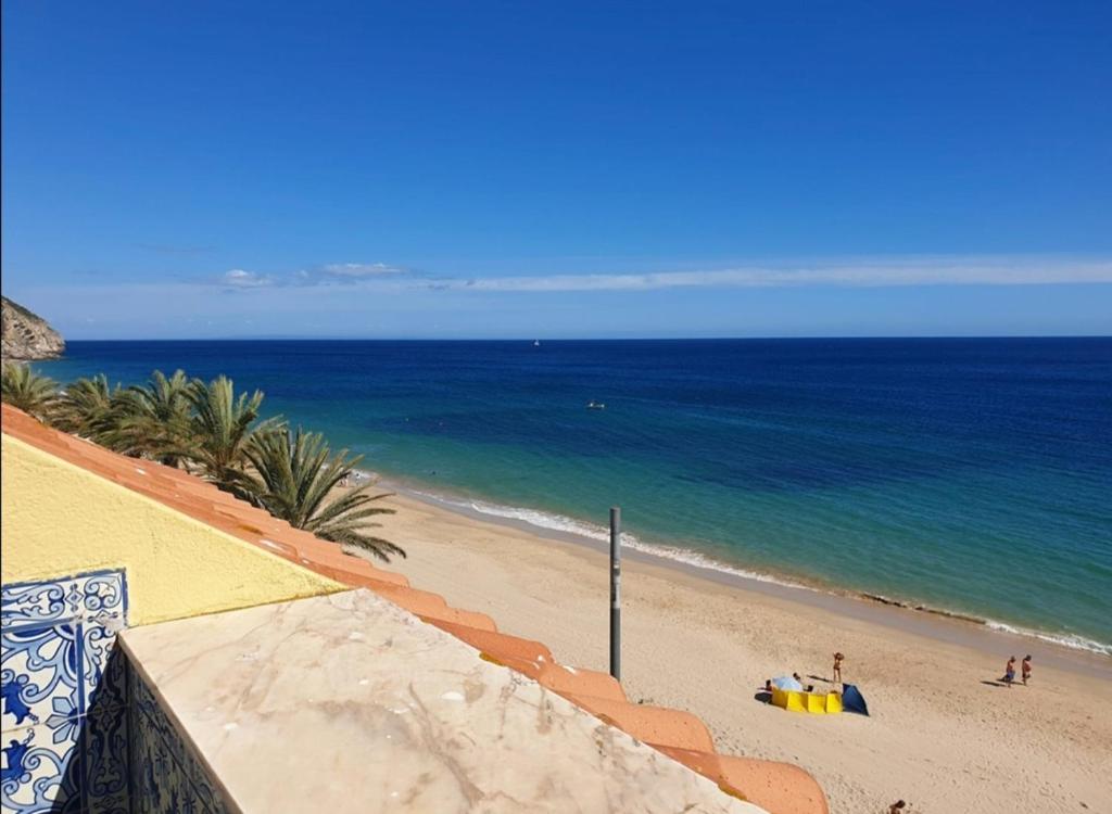 Blick auf den Strand mit dem Meer in der Unterkunft BLUE HOUSE SESIMBRA with parking in Sesimbra