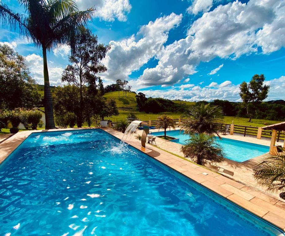 a swimming pool with a person in the water at Pousada São Sebastião in São Sebastião do Rio Verde