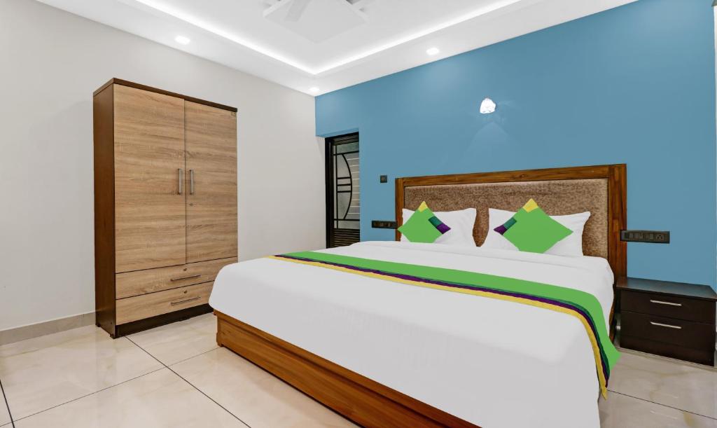 Treebo Trend Pushpak في كوتشي: غرفة نوم مع سرير كبير وخزانة