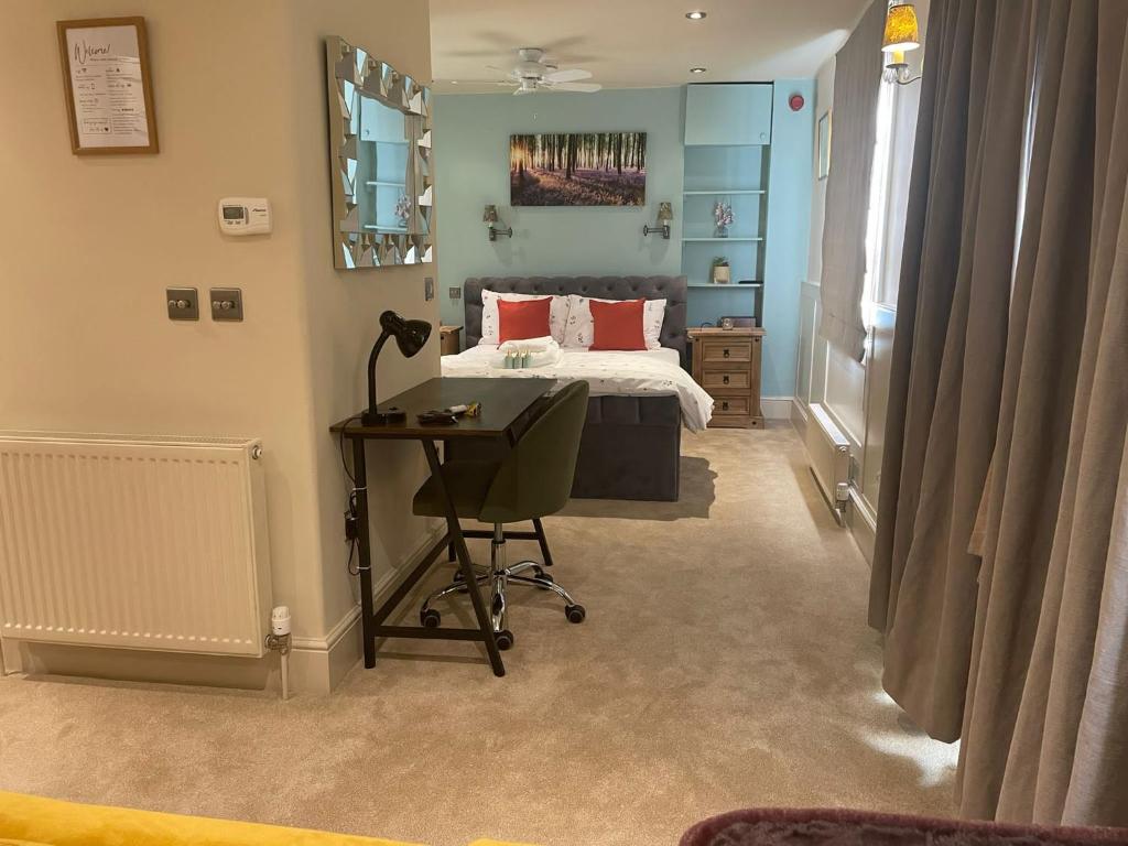 a bedroom with a bed and a desk in it at Studio Flat Central Cheltenham Parking off road in Cheltenham