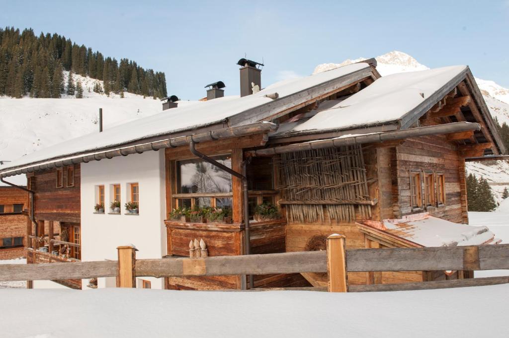 a log cabin with snow on the roof at Appartement Graf in Lech am Arlberg
