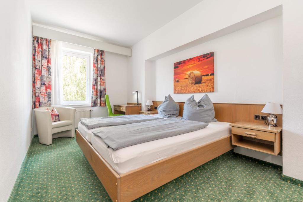 a bedroom with a large bed in a room at Hotel Kniestedter Hof in Salzgitter-Bad