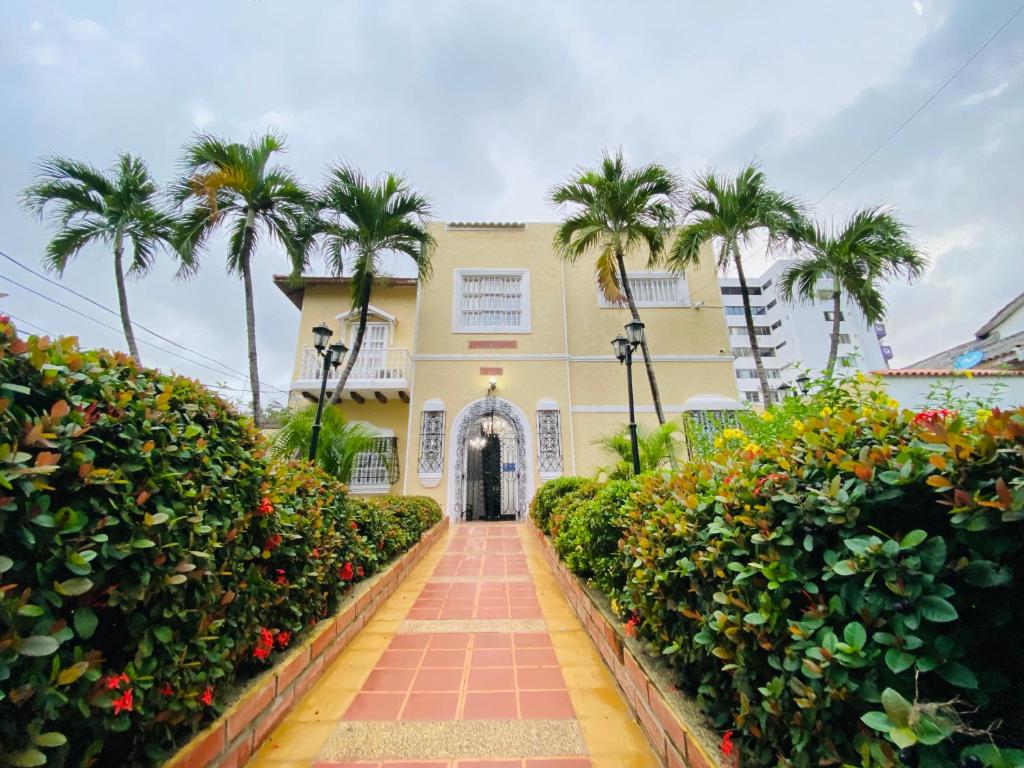 a building with palm trees and a walkway at Hotel Casa Colonial in Barranquilla