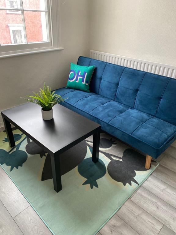 a blue couch in a living room with a table at Spacious 2 Bedroom flat in Paddington in London
