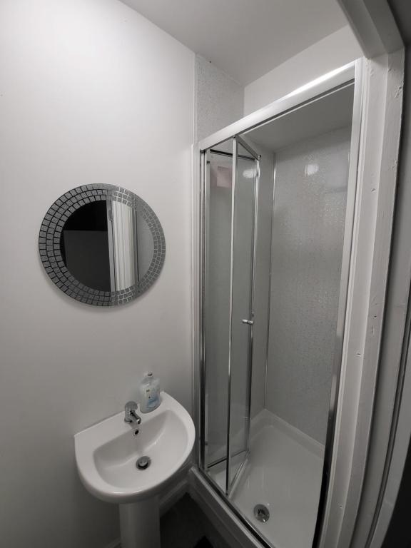 a bathroom with a shower and a sink and a mirror at MM Sure Stay Accommodation - NG1 in Nottingham