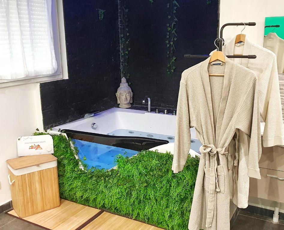 La salle de bains est pourvue d'une baignoire avec un sol en herbe. dans l'établissement Suite Jacuzzi Privatif Plage Des Catalans, à Marseille