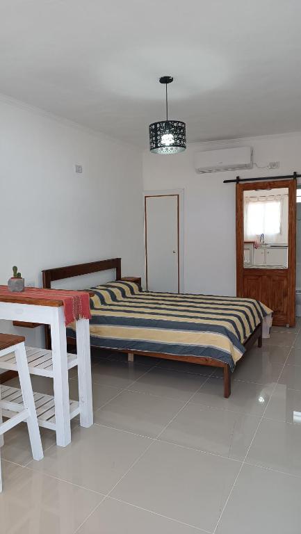 a bedroom with a bed and a table and a window at Caá Guazú in Curuzú Cuatiá