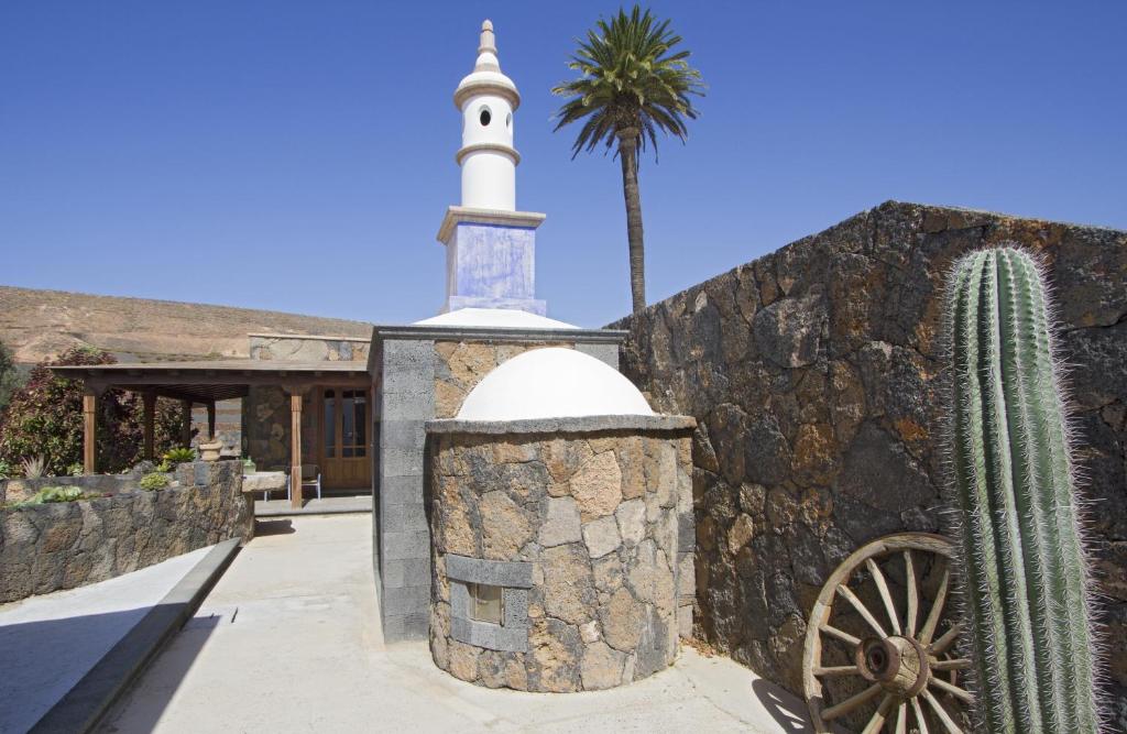 a mosque and a cactus next to a stone wall at Villa Remedios in Teguise