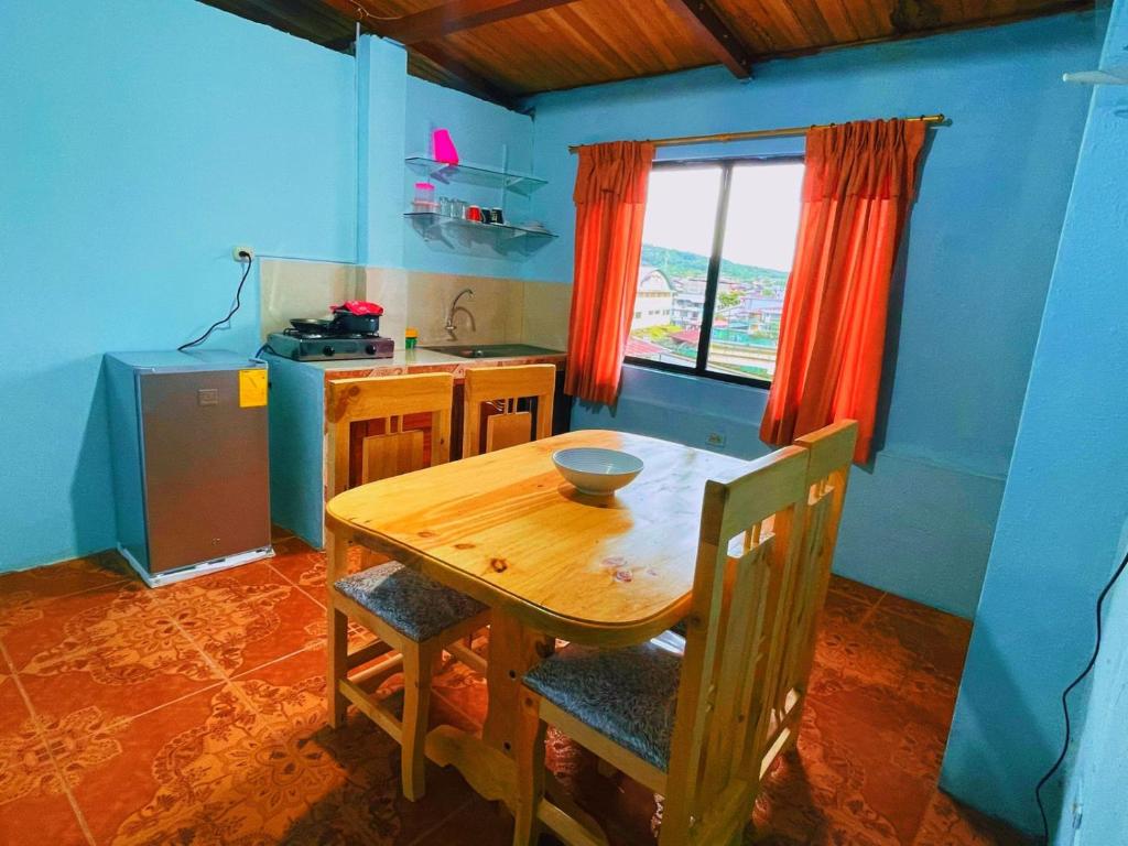 una mesa de madera y sillas en una cocina con ventana en Casa hospedaje Puyo, en Puyo