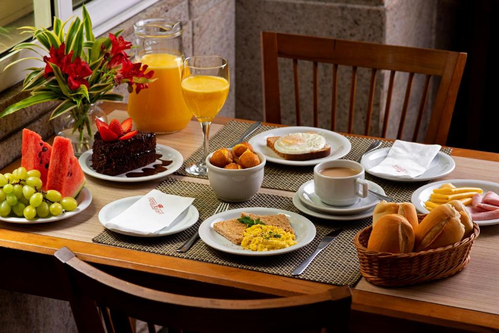 a table topped with plates of food and drinks at Hotel Regina Rio de Janeiro in Rio de Janeiro