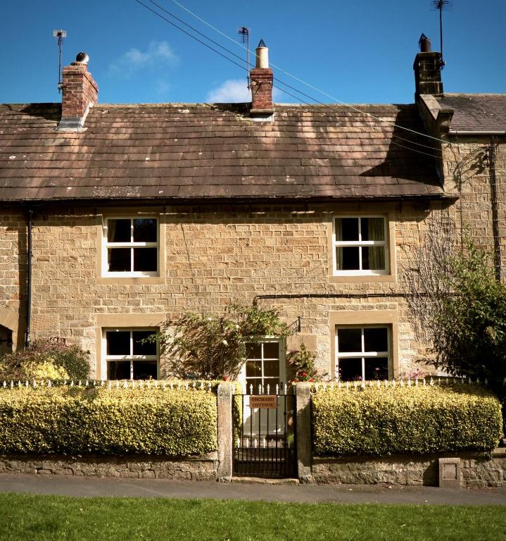 a brick house with a gate in front of it at Orchard Cottage in Ripon