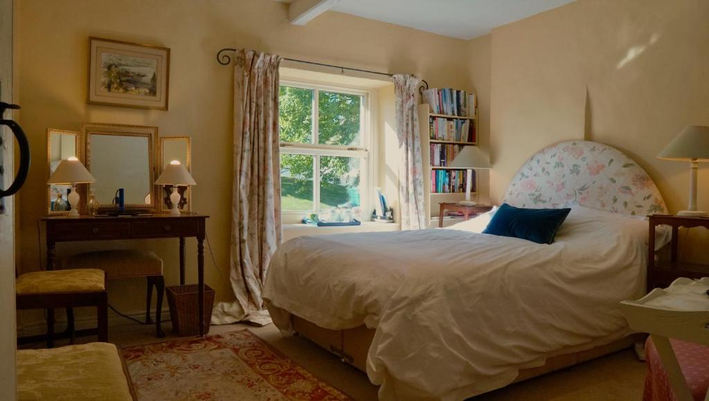 um quarto com uma cama grande e uma janela em Orchard Cottage em Ripon