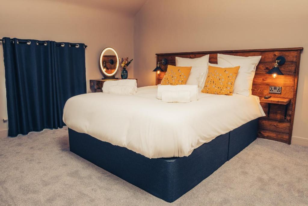 um quarto com uma cama grande com almofadas laranja e branca em Reubens Congleton em Congleton