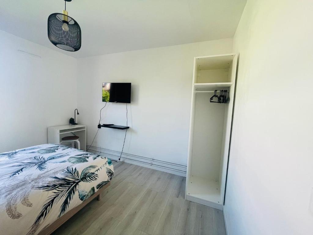 a bedroom with a bed and a door to a closet at Appartement Charmant Cocon Plus in Croix