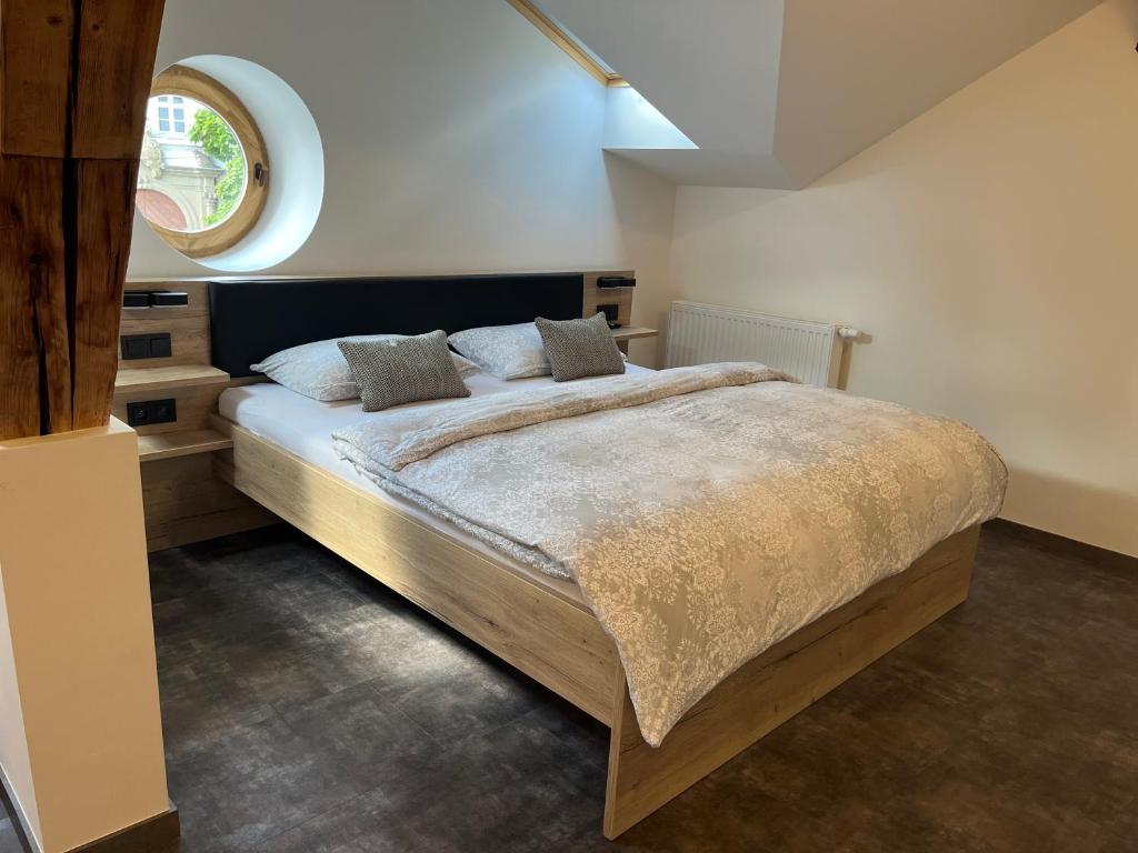 Un dormitorio con una cama grande y una ventana en Penzion a Restaurace ZÁMECKÁ VRÁTNICA en Vizovice