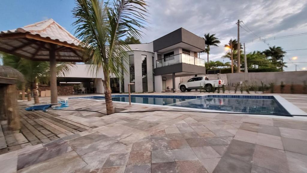 a house with a swimming pool in front of a house at casa de campo porta do sol wifi e pisc aquecida in Mairinque