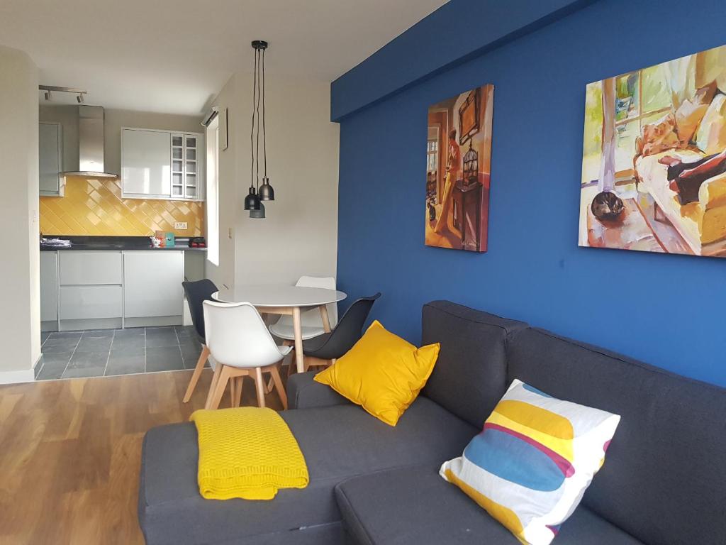 een woonkamer met een grijze bank en gele kussens bij Beautiful 3-bedroom flat with stunning views in Londen