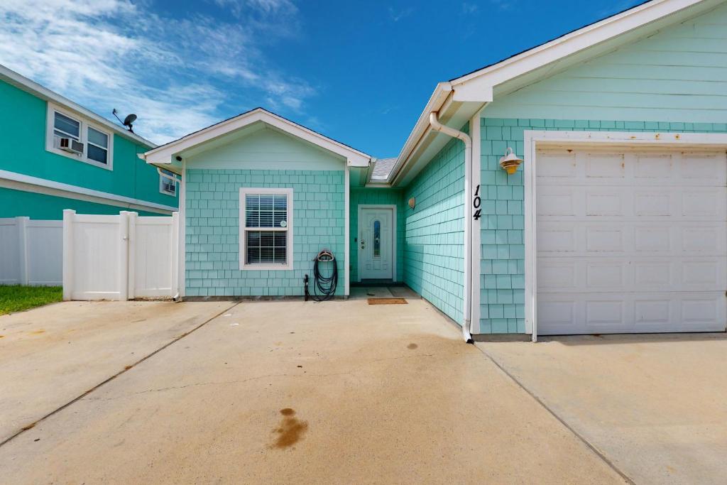 a blue house with a white garage at Morgan Shores in Port Aransas