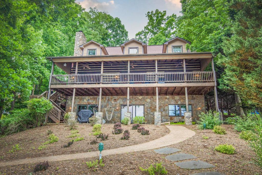 a large house with a wrap around deck and a yard at The Lodge on Smith Mountain Lake in Huddleston