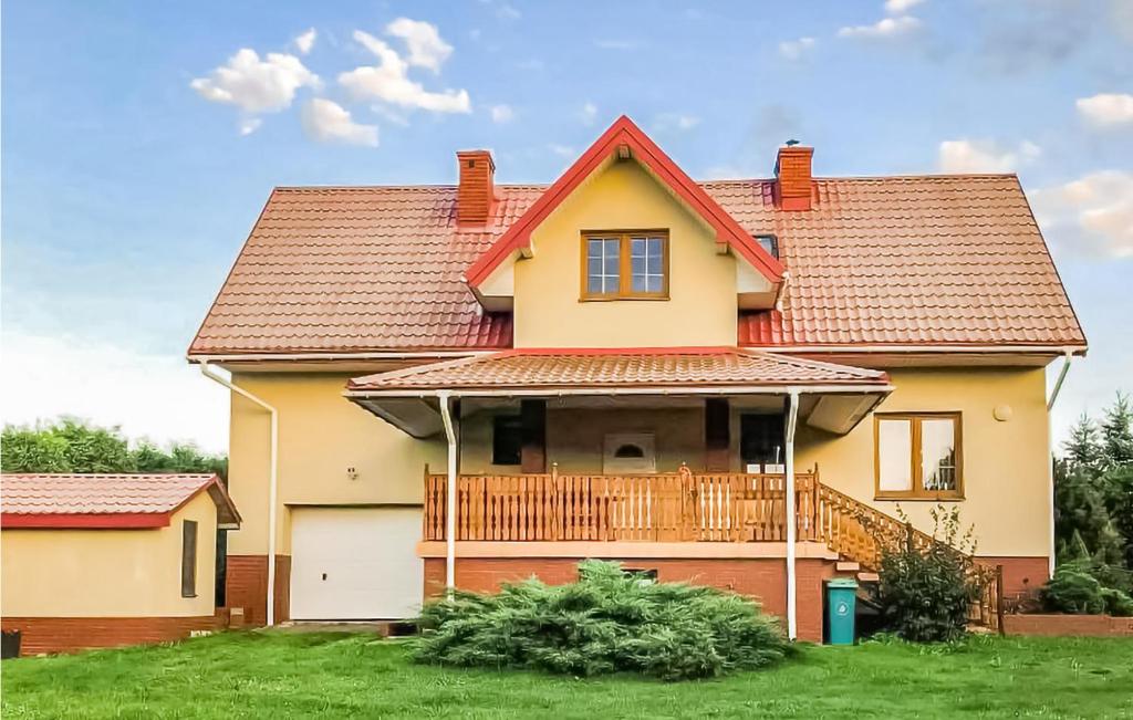 a house with a deck on a lawn at 4 Bedroom Amazing Home In Serniki 