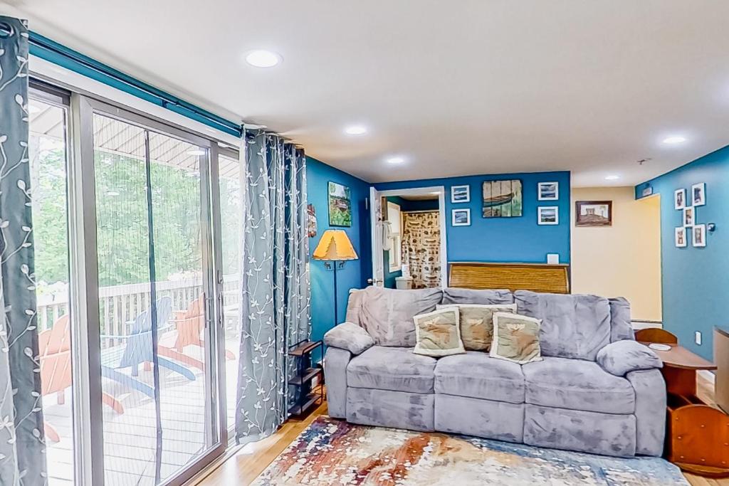 a living room with blue walls and a couch at River Retreat in Brant Lake
