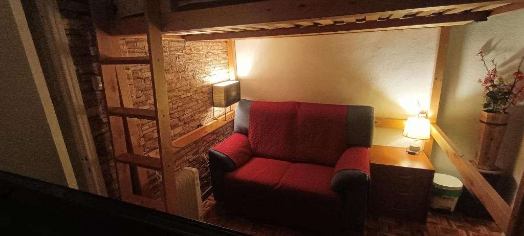 una sedia rossa in una stanza con due lampade di La Doñita2 a Madrid