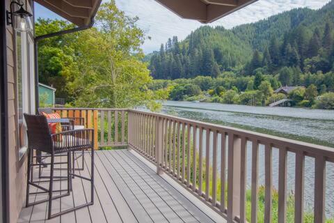 a balcony of a house with a view of a river at Siuslaw River House in Mapleton