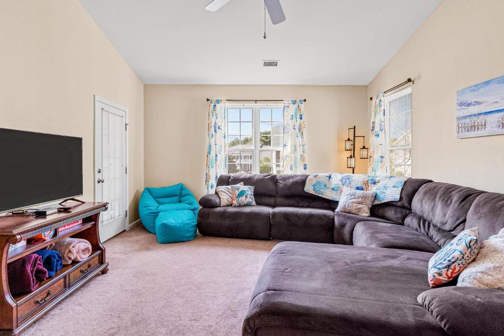 a living room with a couch and a flat screen tv at Coral Reef Retreat in Sunset Beach