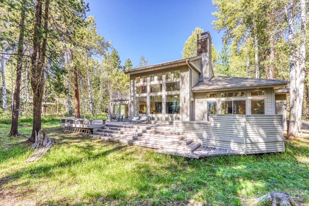 uma casa na floresta com uma casa grande em Black Butte Contemporary em Black Butte Ranch